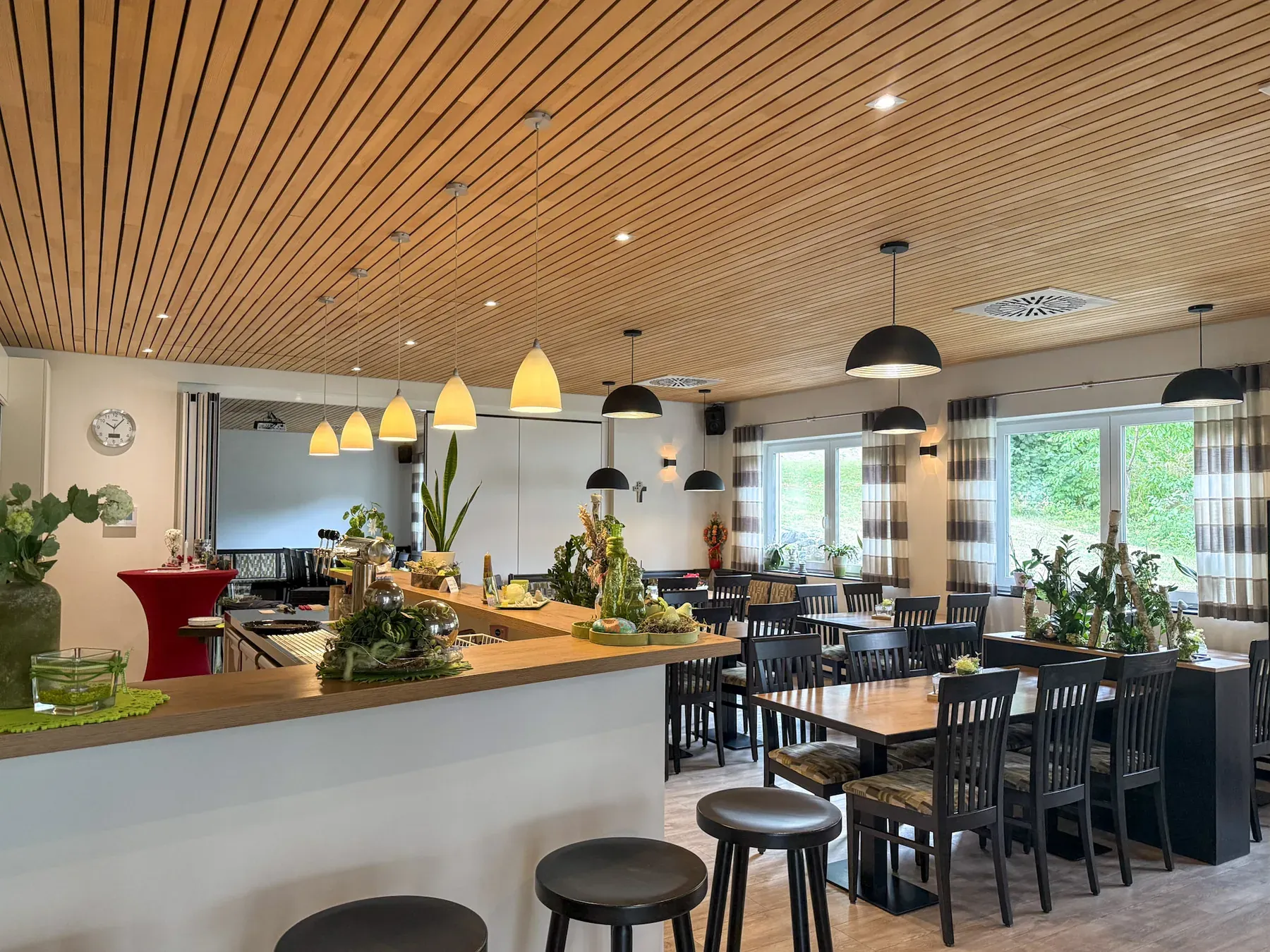 Theke im Gasthaus Löwen mit Barhockern, hellem Holztresen und Gastraum mit Blick ins Grüne